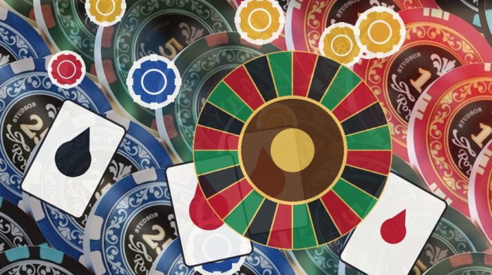 Colorful casino table scene with a roulette wheel, playing cards, and poker chips scattered across the surface.
